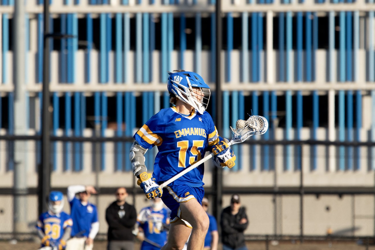 a woman in a blue jersey playing lacrosse